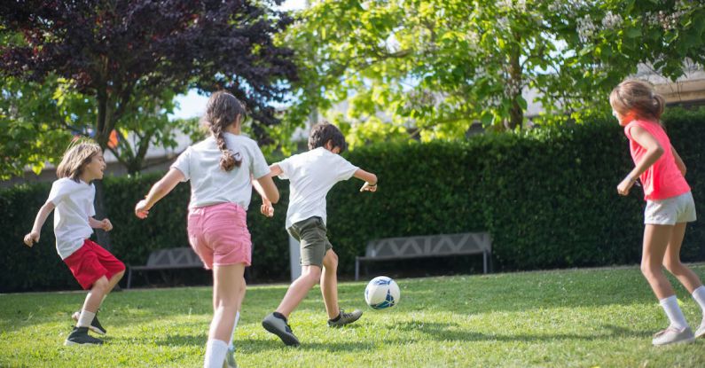 Experiential Activities - Young Kids Playing Football on the Field