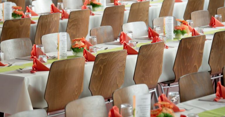 Corporate Event - Long Tables With White Cloths and Brown Chairs Formal Setting