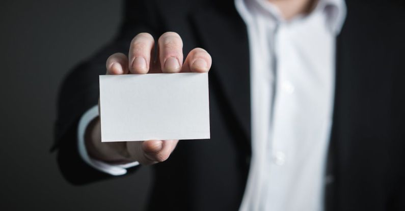 Business Cards - Close-up of Hand Holding Text over Black Background