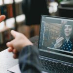 Language Barriers - Young lady learning sign language during online lesson with female tutor